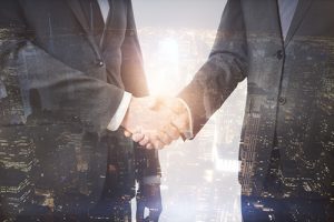 dependable ATM service employee shaking hands with branch manager with city lights overlay