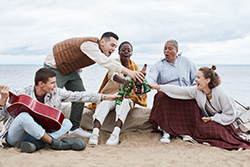 Community of friends hanging out on the beach; benefits of homes for sale in Point Pleasant NJ