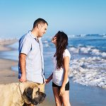 Couple enjoying coastal lifestyle provided by Lavallette real estate walking dog on the beach